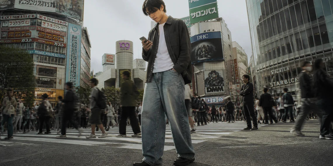 A stylish man wearing wide leg jeans for a trendy cityboy look.