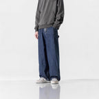 模特兒穿著藏青色抽繩闊腿工裝牛仔褲半身正面，呈現重磅丹寧自然垂墜感