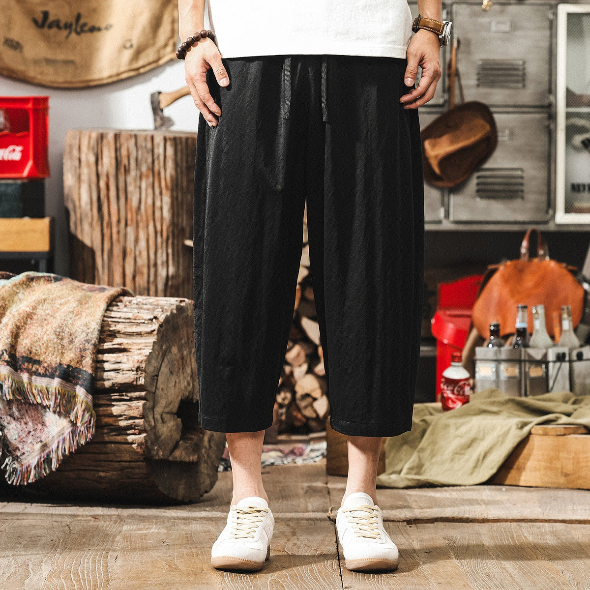 男生穿著 FLOW系列極簡黑色寬鬆七分休閒褲，棉麻混紡材質透氣不悶熱，日常百搭首選。